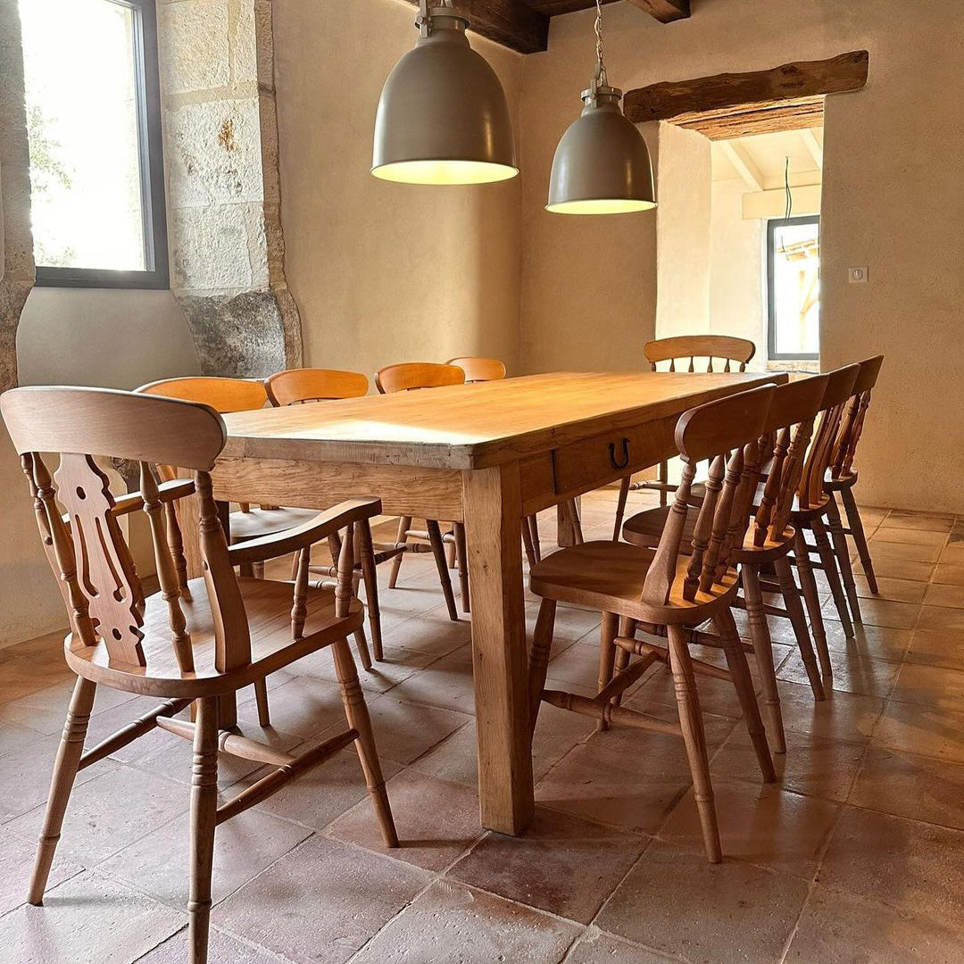A rustic dining room interior with a wooden dining table and stone floor